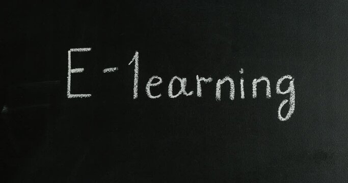 Hand writes with chalk on a chalk board the word E-Learning. 4K stop motion animation