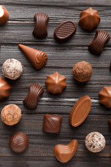 Assorted chocolates on dark wooden background top view