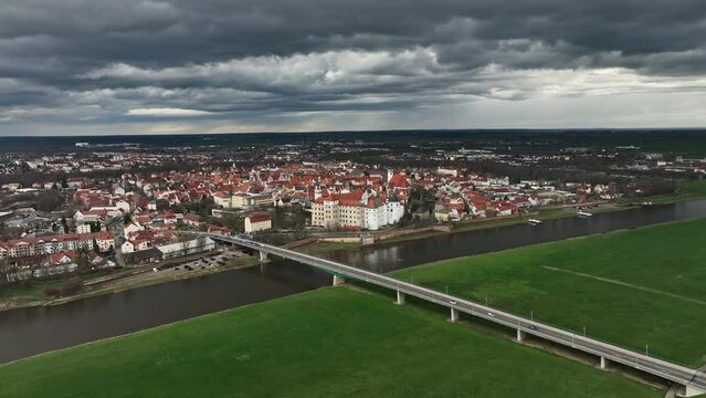 flight towards torgau under a cloudy sky. the river elbe in the foreground. the city center in the background. dramatic sky just before the rain