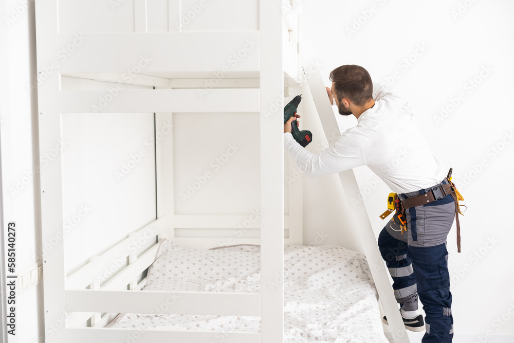 Wall mural a worker repairs furniture in a children's room