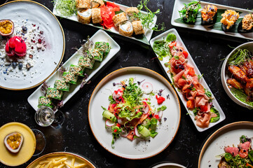 variety of restaurant food dishes on table. top view.