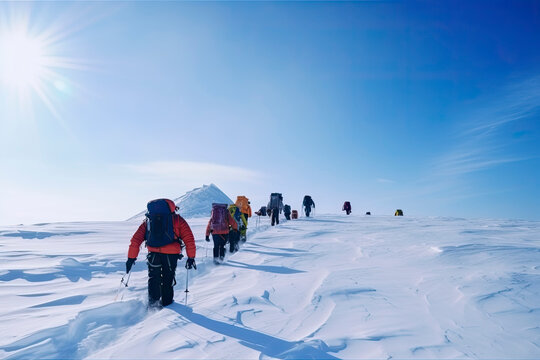 Group of mountain climbers climb the slope to the peak in sunny weather with sledges and tents equipment for overnight stays