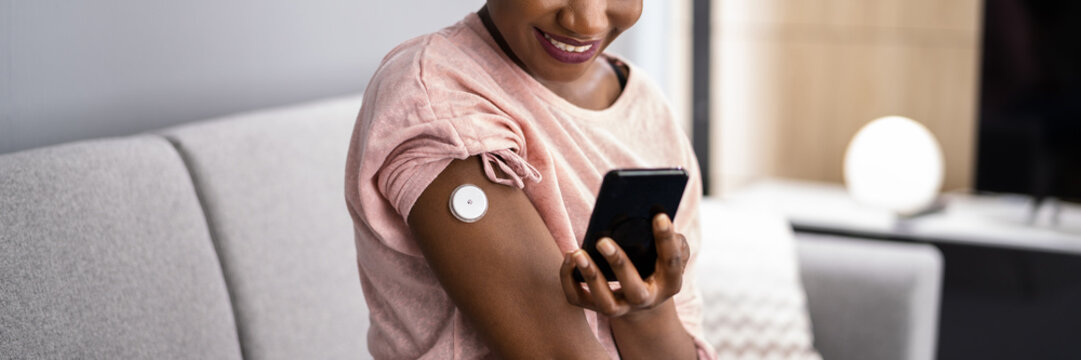 Woman Testing Glucose Level With Continuous Glucose Monitor