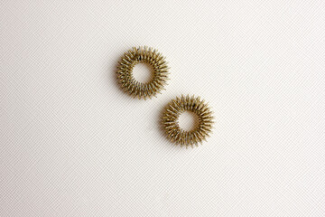 Prickly metal rings for acupressure finger insulated on a light background. .healing of the body, acupressure. Massage of hands and feet.