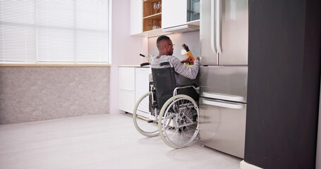 Young Disabled Man Sitting On Wheel Chair Preparing Food