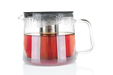 Glass teapot with hot tea close up on a white background