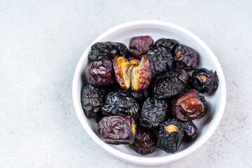 Raw Organic Arabic Dates, Ajwa Dates on light gray background. Ramadan Kareem. Close up.
