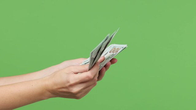 Close up cropped female hold in hand count stack of cash money win in dollar banknotes isolated on pastel plain light green color wall background studio. Finance concept Copy space advertising mock up