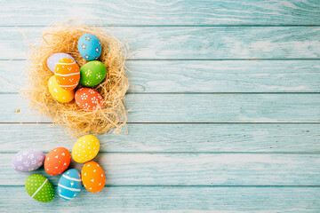 Happy Easter Day Concept. Flat lay of holiday banner background web design easter eggs in brown nest on blue wooden background with empty copy space, celebration greeting card, overhead, template