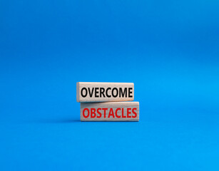 Overcome obstacles symbol. Concept words Overcome obstacles on wooden blocks. Beautiful blue background. Business and Overcome obstacles concept. Copy space.