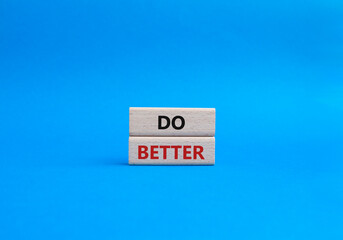 Do better symbol. Wooden blocks with words Do better. Beautiful blue background. Business and Do better concept. Copy space.