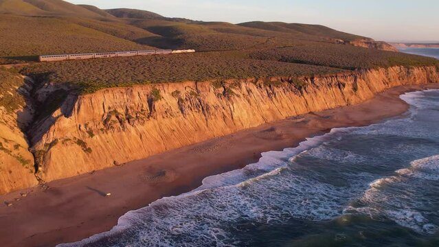 2023 - Excellent aerial footage of waves lapping the shores of Jalama Beach, California, as a train passes by.