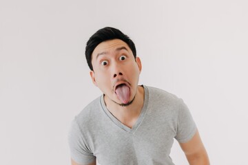 Funny tease and bully face of Asian man in grey t-shirt isolated on white.