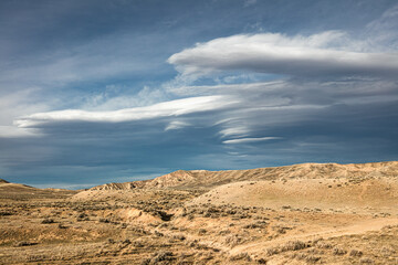 Fototapeta premium Lenticular clouds over the Bighorn Basin desert landscape in the northwest wilderness of Wyoming. 