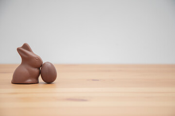 Chocolate bunny and chocolate eggs on a wooden table. Easter background.