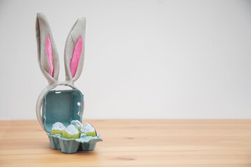 Chocolate baby bunny and chocolate eggs on a wooden table. Easter background.