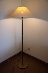 Interior with floor lamp and glow bulb in the dark at night, one lamp in the corner against a floor lamp wall.