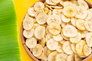 Banana slice chips on yellow background.