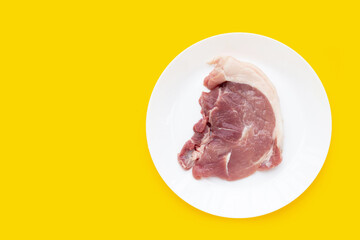 Pork meat on yellow background.