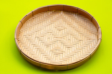 Bamboo weave plate on green background.