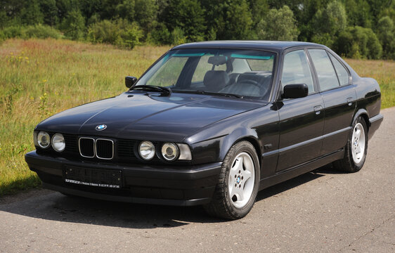 Belarus, Minsk-02.07.2012:Black classic car BMW E34 5-series on the autumn road.