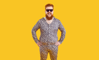 Portrait of funny comic fat man in leopard pajamas who laughs out loud on orange background....