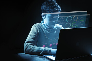 10-year-old boy typing on computer with holographic screens and blue tint