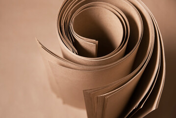 Roll of brown kraft paper for packaging various products, production of ecological bags, top view,...