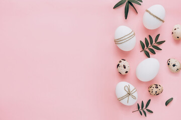 Composition with Easter eggs and spring flowers on pink background. Minimal easter concept.