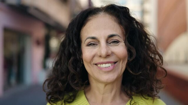 Middle age hispanic woman smiling confident at street