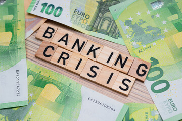 inscription banking crisis next to euro banknotes. Concept showing the bad situation of banks in Europe.