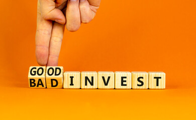 Good or bad invest symbol. Concept word Good invest and Bad invest on wooden cubes. Beautiful orange table orange background. Businessman hand. Business good or bad invest concept. Copy space.