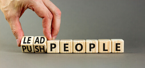 Lead or push people symbol. Concept word Lead people and Push people on wooden cubes. Beautiful grey table grey background. Businessman hand. Business Energy or hunger crisis concept. Copy space.