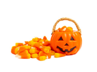 Corn candy in isolated on white background.Halloween concept. Bucket of Halloween pumpkin Jack-o-lantern with candy corn for halloween celebration.Pumpkin with a scary smile on his face.Candy bucket.