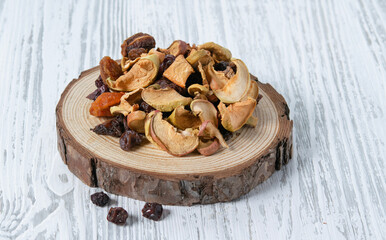 Dry fruits apple and cherry in a wooden board  on a white wooden background. Rustic style.