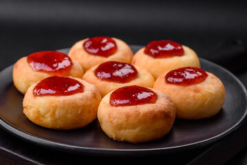 Delicious fresh cottage cheesecakes with raisins and vanilla on a black ceramic plate
