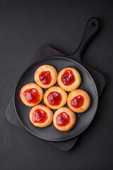 Delicious fresh cottage cheesecakes with raisins and vanilla on a black ceramic plate