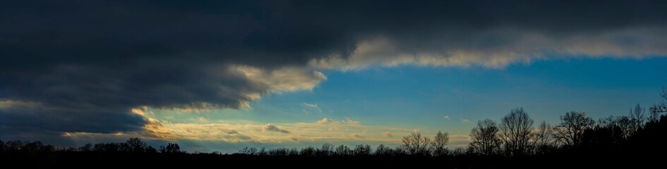 Fototapeta na wymiar Forest, dark clouds at sunset.