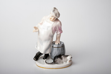 Rare porcelain figurines on a white background. Fat cook and cat eats fish
