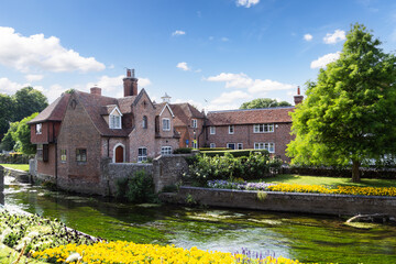 The Great Stour river flows past beautiful old houses at Westgate Gardens in the picturesque...