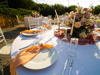 Table at luxury wedding reception event. Beautiful flowers on table and serving dishes and glasses and decoration