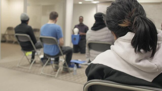 CPR training class by security guard in office