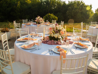 Table at luxury wedding reception event. Beautiful flowers on table and serving dishes and glasses and decoration