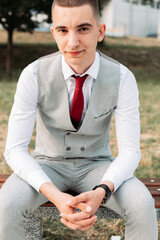 Young teenage boy sitting in a gray suit ready for a prom night. © stivog