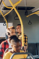 Man standing in a bus during a ride