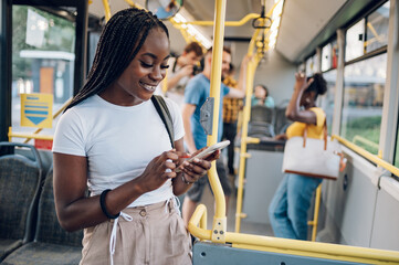 African american woman riding in a bus and using a smartphone