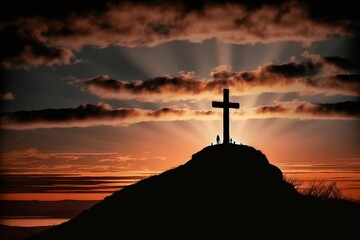 Silhouette of a crucifix on a lonely hill with sunset