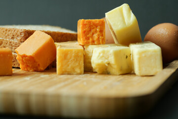 Cheese cubes green, yellow and red color on chopping board 