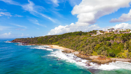 Aerial, drone view of the spectacular Sunshine Coast city near Brisbane. Beautiful buildings on the cliffs and golden sand bays- first and second bay. Landscape of Queensland, Australia