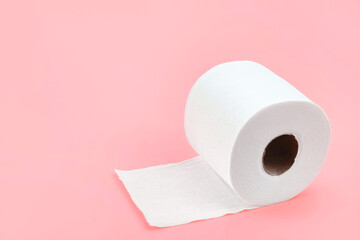 Toilet paper roll isolated on pastel pink background. Fresh colour with soft paper texture. Everyday object, design element, close up and copy space.